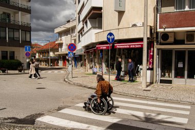 Fatima, Portekiz - 24 Mart 2025: Portekiz 'in Fatima şehrinde tekerlekli sandalyede bir kişi ile geçiş sahnesi