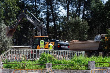 Fatima, Portekiz - 26 Mart 2025: Hyundai makineleri ve doğa tarafından çevrelenmiş personel kazı çalışmaları