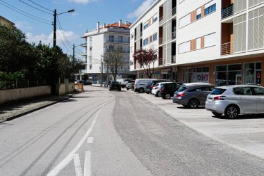 Fatima, Portekiz - 26 Mart 2025: Portekiz 'in Fatima kentindeki apartman ve park halindeki araçların yer aldığı şehir caddesi