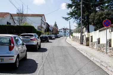 Fatima, Portekiz - 26 Mart 2025: Fatima, Portekiz 'de sakin mahalle caddesi, park halindeki arabalar ve yol işaretleri.