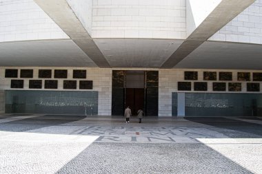 Fatima, Portekiz - 26 Mart 2025: Fatima, Portekiz 'de yürüyen ziyaretçilerle çağdaş bir bina cephesi.