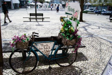 Fatima, Portekiz - 26 Mart 2025: Portekiz 'in manzaralı şehir meydanı Fatima' da canlı çiçekler sergileyen süslü bir bisiklet.
