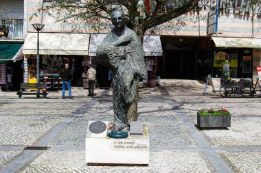 Fatima, Portekiz - 26 Mart 2025: Portekiz 'de bir sokak ortamında görülen insanlar ve binalar ile birlikte bronz heykel Luis Kondor 
