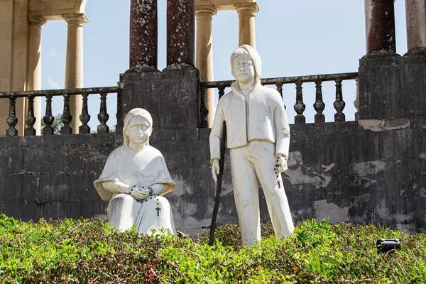 Fatima, Portekiz - 26 Mart 2025: Çevresi yeşillik ve tarihi mimari ile çevrili iki tefekkür figürü