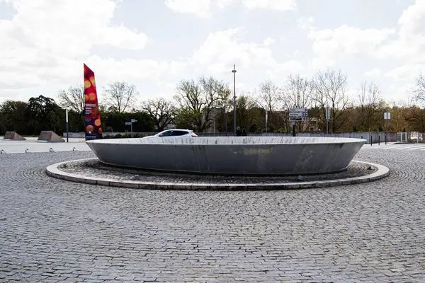 Fatima, Portekiz - 26 Mart 2025: Fatima, Portekiz 'de ağaçlar ve gökyüzü ile döner kavşakta dairesel metal heykel.