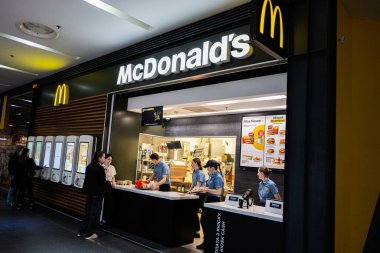 Lviv, Ukrayna - 31 Mart 2025: Personelin yemek hazırlamasıyla ve müşterilerin sipariş vermesiyle McDonald 's' ın yeri.
