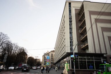 Lviv, Ukrayna - 31 Mart 2025: Lviv Oteli, kalabalık bir yolda insanlar ve araçlarla şehir caddesi manzarası.