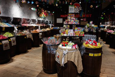 Lviv, Ukrayna - 31 Mart 2025: Canlı bir şekerci dükkanında variller dolusu şeker ve renkli süslemeler sergileniyor.