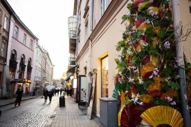 Lviv, Ukrayna - 31 Mart 2025: Lviv, Ukrayna 'da günbatımında sanatsal çiçek ve fan dekorasyonlarıyla dolu canlı bir sokak. 