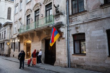 Lviv, Ukrayna - 31 Mart 2025: Lviv, Ukrayna 'da tarihi bir sokakta bayrakları ve insanları bulunan bina