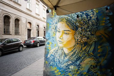 Lviv, Ukrayna - 31 Mart 2025: Ukrayna 'nın başkenti Lviv' de canlı bir şehir ortamında kültürel bir portre sergileyen bir sokak yazısı. 