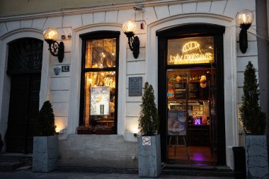 Lviv, Ukrayna - 31 Mart 2025: Lviv, Ukrayna 'da neon ışıkları, rahat dekor ve sokak manzaralı büyüleyici fırın girişi. 