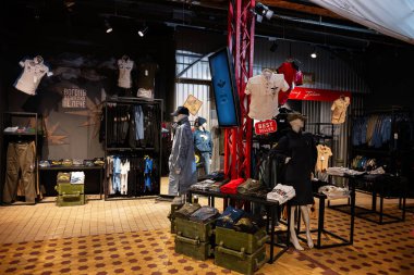 Lviv, Ukrayna - 31 Mart 2025: Mankenler, masalar ve asılı giysiler sergilenen bir giyim mağazası.