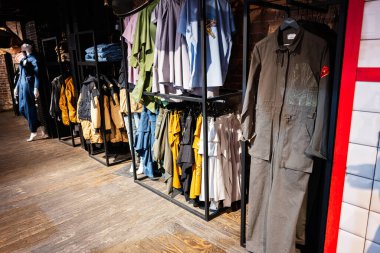 Lviv, Ukrayna - 31 Mart 2025: Bir butik moda dükkanında raflarda sergilenen şık ve modaya uygun kıyafetler.