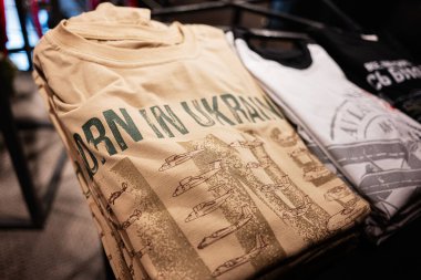 Lviv, Ukrayna - 31 Mart 2025 Ukrayna doğumlu. Bir giyim mağazasında satılık Ukrayna temalı grafikli katlanmış tişörtler.