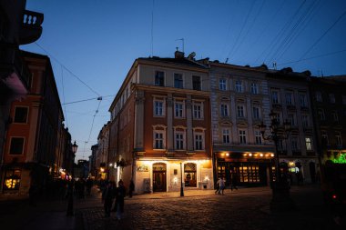 Lviv, Ukrayna - 31 Mart 2025: Işıklı binalar ve tarihi mimari güzelliğin yer aldığı büyüleyici gece Lviv sahnesi.