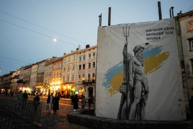Lviv, Ukrayna - 31 Mart 2025: Ukrayna 'nın Lviv şehir meydanındaki Neptün heykeli, tarihi mimari geçmişi gün batımında.
