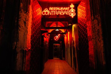 Lviv, Ukrayna - 31 Mart 2025: Sıcak ve çevre aydınlatmalı büyüleyici bir restoran Kaçakçılığı geçidine yol gösteren neon tabela