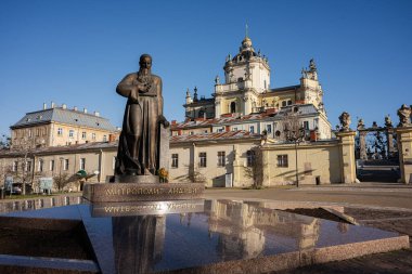 Lviv, Ukrayna - 31 Mart 2025: St. George Katedrali. Bronz heykel Andrey Sheptytsky 'nin tarihi bir barok katedrali ve Ukrayna' nın Lviv şehrinin arka planında mavi gökyüzü var.. 