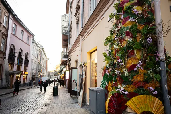 Lviv, Ukrayna - 31 Mart 2025: Lviv, Ukrayna 'da günbatımında sanatsal çiçek ve fan dekorasyonlarıyla dolu canlı bir sokak. 