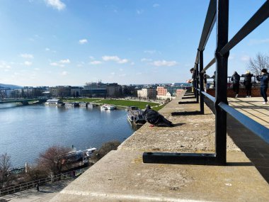 Krakow, Polonya - 16 Mart 2025: Şehir manzaralı sakin nehir manzarası ve Krakow 'daki açık havanın tadını çıkaran insanlar.