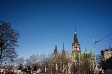 Lviv, Ukrayna - Nisan 01, 2025: Gotik bir Aziz Kilisesi manzarası. Güneşli bir günde Olha ve Elizabeth ağaçlarla çevrili.