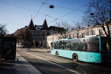 Lviv, Ukrayna - 01 Nisan 2025: Açık gökyüzünün altından geçen bir otobüsle sakin bir Lviv caddesinin sabah görüntüsü.