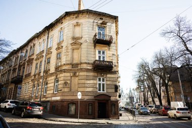 Lviv, Ukrayna - 01 Nisan 2025: Lviv şehrinde arabalarla ve parlak güneşli gökyüzüyle süslü tarihi bina. Politekhnichna Caddesi.