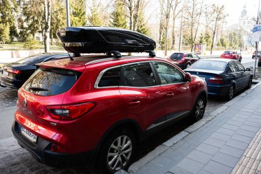Lviv, Ukrayna - Nisan 01, 2025: Lviv 'de bir şehir caddesinde Thule Motion çatı kutusuyla donatılmış açık kırmızı Renault Kadjar arabası