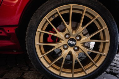 Lviv, Ukrayna - 01 Nisan 2025: Altın BBS alaşımlı tekerlek ayrıntısı kaldırım döşemesindeki kırmızı bir arabada sergilendi