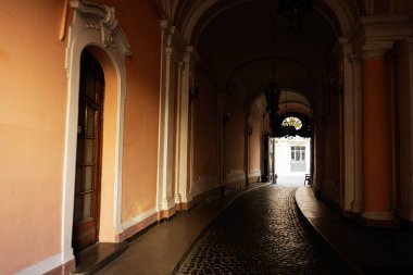 Lviv, Ukrayna - Nisan 01, 2025: Avlu girişine açılan klasik mimarisi olan sakin kemerli bir koridor. Bilim Adamları Evi