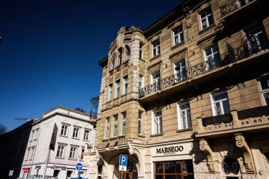 Lviv, Ukrayna - Nisan 01, 2025: Parlak güneşli bir günde tarihi mimari sergilenen zarif bina cepheleri