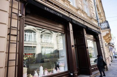 Lviv, Ukrayna - 1 Nisan 2025: Lviv kentsel caddesini yansıtan dekoratif pencereli büyüleyici bir Knyazev Cafe cephesi.