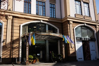 Lviv, Ukrayna - 1 Nisan 2025: Lviv 'deki Rius Hotel binası zarif mimarisi ve ulusal bayraklarını sergiliyor.
