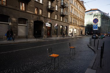 Lviv, Ukrayna - 1 Nisan 2025: Lviv kentsel sokak, sandalyeli ve tarihi mimari gündüz