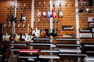 Lviv, Ukrayna - 01 Nisan 2025: Gitarlar ve klavyeler canlı ve çeşitli bir müzik mağazasında sergilendi.