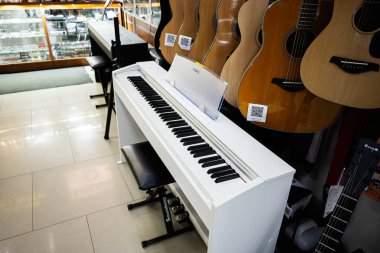 Lviv, Ukrayna - 01 Nisan 2025: Gitar ve aksesuarlarla birlikte beyaz dijital Casio piyanosu bir müzik dükkanında sergilendi 