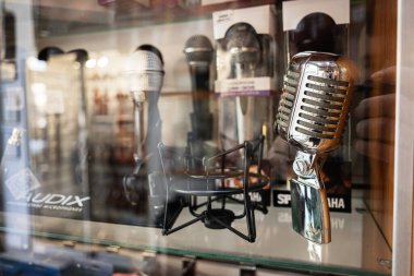 Lviv, Ukrayna - 01 Nisan 2025: Retro mikrofonlar bir müzik dükkanında cam arkasında sergilendi