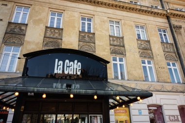 Lviv, Ukrayna - Nisan 06, 2025: Süslü dekoratif unsurları olan tarihi bir binanın altındaki klasik kafe girişi