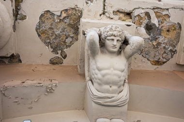 Lviv, Ukrayna - Nisan 06, 2025: Lviv, Ukrayna 'da boya ve çürüme ile işaretlenmiş eski bir iç mekan içinde klasik bir heykel.