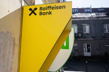 Lviv, Ukrayna - Nisan 06, 2025: Açık sarı Raiffeisen Bank tabelası kentsel mimari geçmişe sahip bir binaya monte edildi