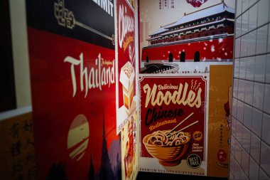 Lviv, Ukrayna - Nisan 06, 2025: Renkli kültürel öğeler ve canlı tasarımlarla erişte mutfağı sergilenen restoran posterleri.