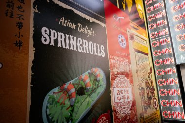 Lviv, Ukrayna - Nisan 06, 2025: Spring Rolls ve kültürel tasarımların sergilendiği Asya tarzı yemek posterlerinin yakından görüntüsü