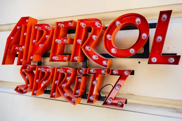 Lviv, Ukrayna - Nisan 06, 2025: Duvarda kırmızı ve sarı renkler bulunan parlak ışıklı Aperol Spritz işareti.