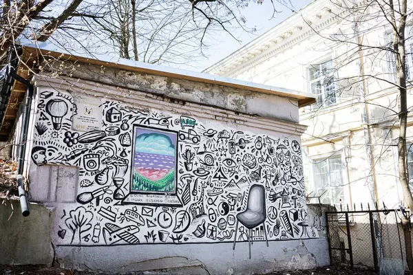 Lviv, Ukrayna - Nisan 06, 2025: Lviv, Ukrayna 'daki bir bina duvarında sanatsal çizimler ve renkli çerçeveli bir resim.