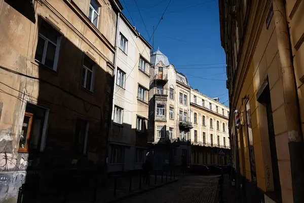 Lviv, Ukrayna - Nisan 06, 2025: Dar bir cadde boyunca açık gökyüzü ve parlak güneş ışığı olan eski binalar