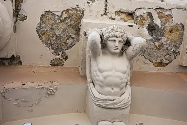 Lviv, Ukrayna - Nisan 06, 2025: Lviv, Ukrayna 'da boya ve çürüme ile işaretlenmiş eski bir iç mekan içinde klasik bir heykel.