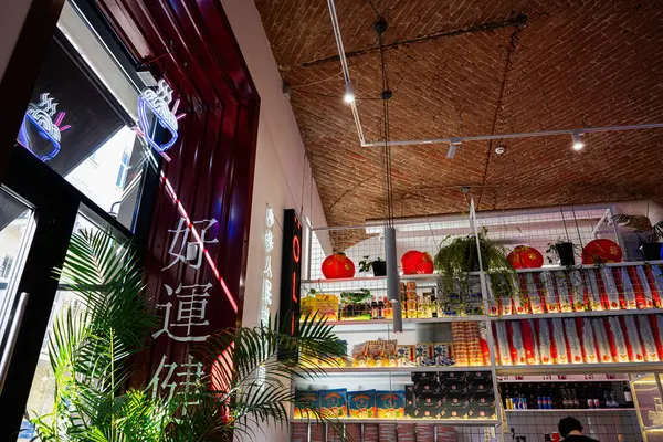 Lviv, Ukrayna - Nisan 06, 2025: Asyalı elementlere sahip modern kafe, neon ışıkları, kırmızı süslemeler ve bitkilerin yer aldığı.