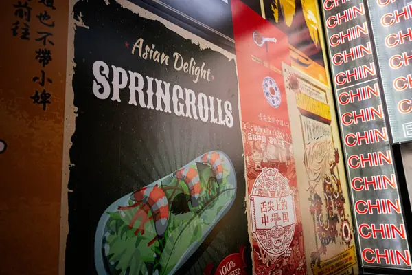 Lviv, Ukrayna - Nisan 06, 2025: Spring Rolls ve kültürel tasarımların sergilendiği Asya tarzı yemek posterlerinin yakından görüntüsü