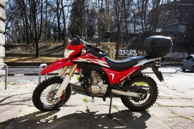 Lviv, Ukrayna - Nisan 06, 2025: Kırmızı toprak dayanıklı Honda XR250 motosiklet off-road lastikleri güneş ışığı altında asfalt bir alana park edilmiş